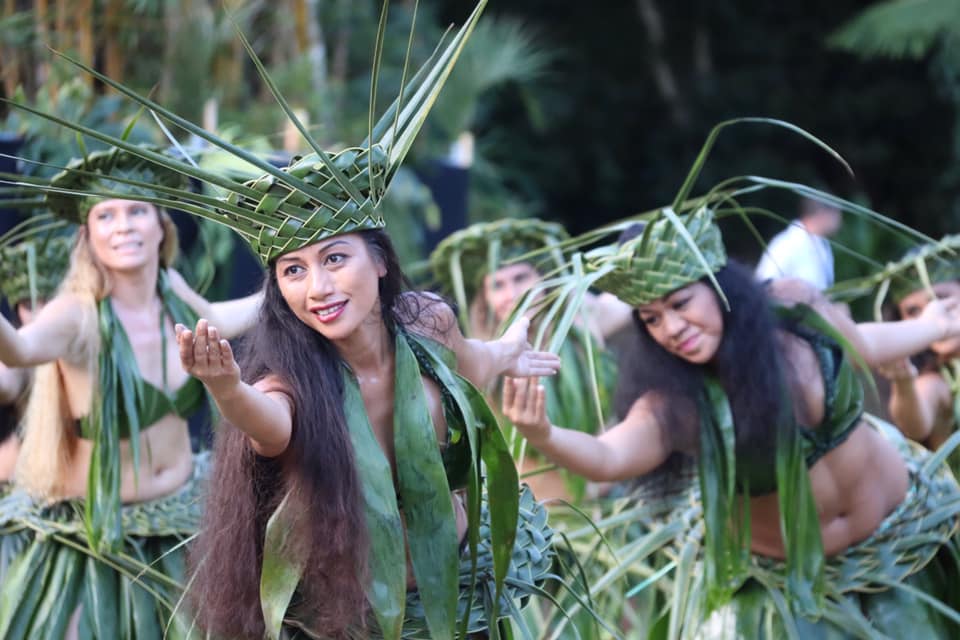 Девушки в растительных костюмах танцуют полинезийский танец